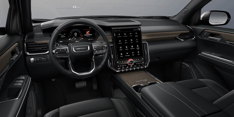 Wide View of the Front Row Seating, Steering Wheel, and Dashboard in a 2024 GMC Acadia Mid-Size SUV