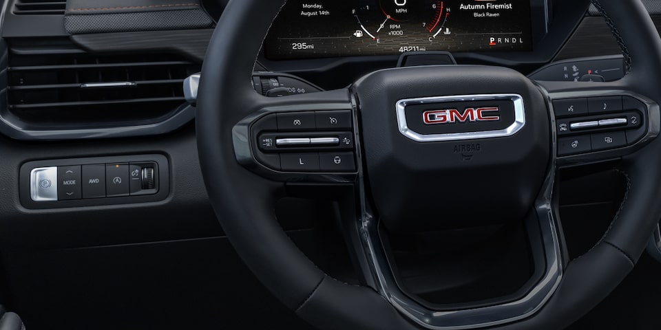 Close-up of the Traction Select Button Near the Steering Wheel in a 2024 GMC Acadia AT4 SUV