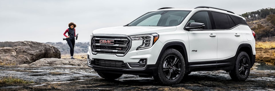A Person Walking Towards Their Parked GMC Terrain Outside