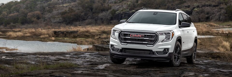 A White GMC Terrain Driving Off-Road in the Mud