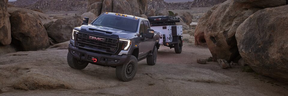 The Sierra HD AT4 Towing a Camper Through a Narrow Mountain Road Incline