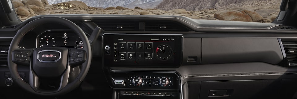 Close-up View of the Dashboard, Steering Wheel, and Infotainment Screen in a 2024 GMC Sierra HD AT4 Off-Road Work Truck