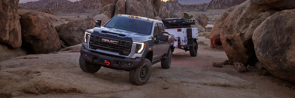 The Sierra HD AT4 Towing a Camper Through a Narrow Mountain Road Incline