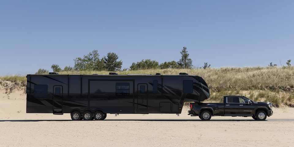 The Sierra HD Denali Parked while Attached to a Large Camper