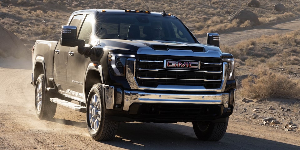 The GMC Sierra HD Pro Driving Off-Road Kicking Up Dirt