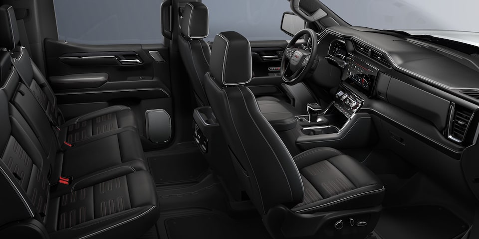 Side View of the Front and Second Row Seating, Steering Wheel, and Dashboard in a 2024 GMC Acadia Mid-Size SUV