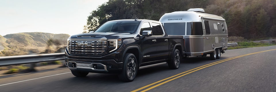 The Powerful GMC Sierra LD Denali Driving On-Road Towing a Trailer
