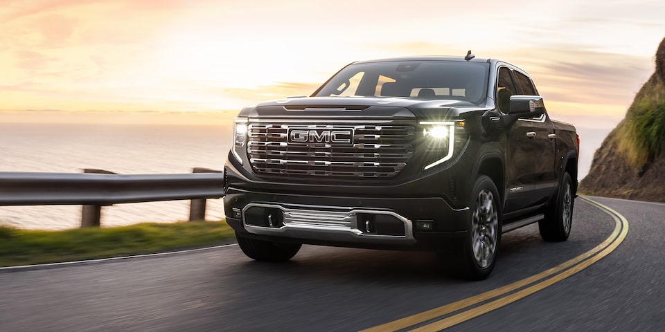 The GMC Sierra LD Denali Driving On-Road During a Sunset