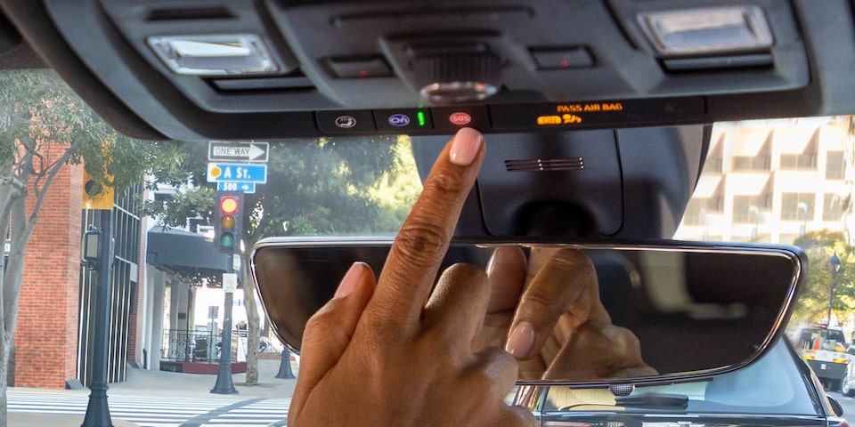 A Person Clicking the GMC Sierra LD Denali OnStar Connected Services Button