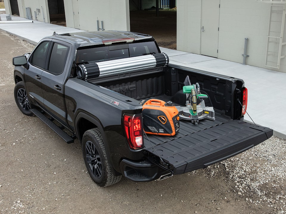 Rear Three-Quarters View of a 2024 GMC Sierra 1500 Pickup Truck with the Truck Bed Full of Tools