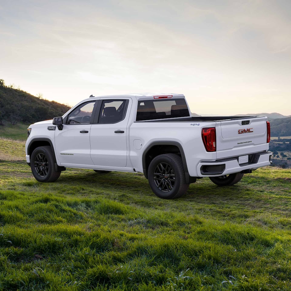 A Side-Profile Shot of a White GMC Sierra LD Parked Off-Road