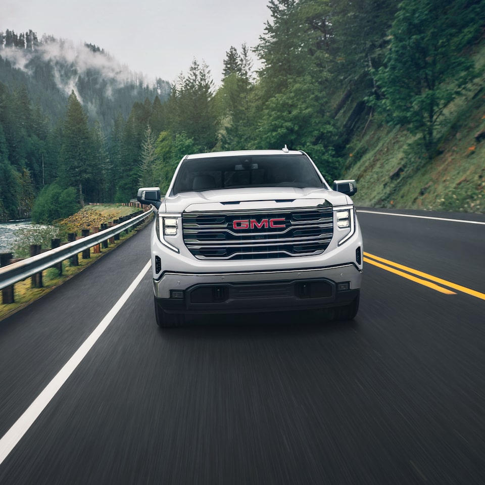 A Head-On Shot of the White GMC Sierra Driving On-Road