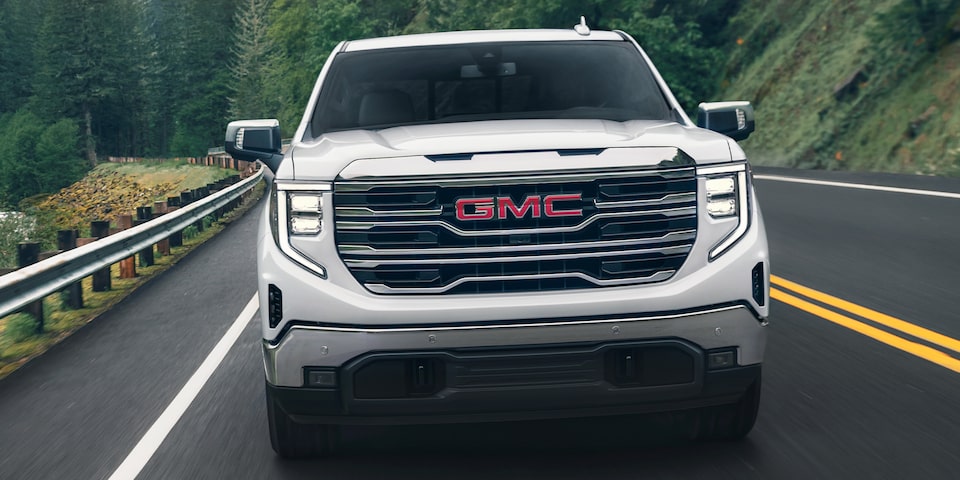 A Front View of a White 2024 GMC Sierra 1500 SLE Driving On-Road