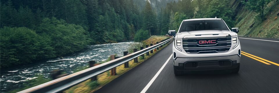 A Head-On Shot of the White GMC Sierra LD SLE Driving On-Road
