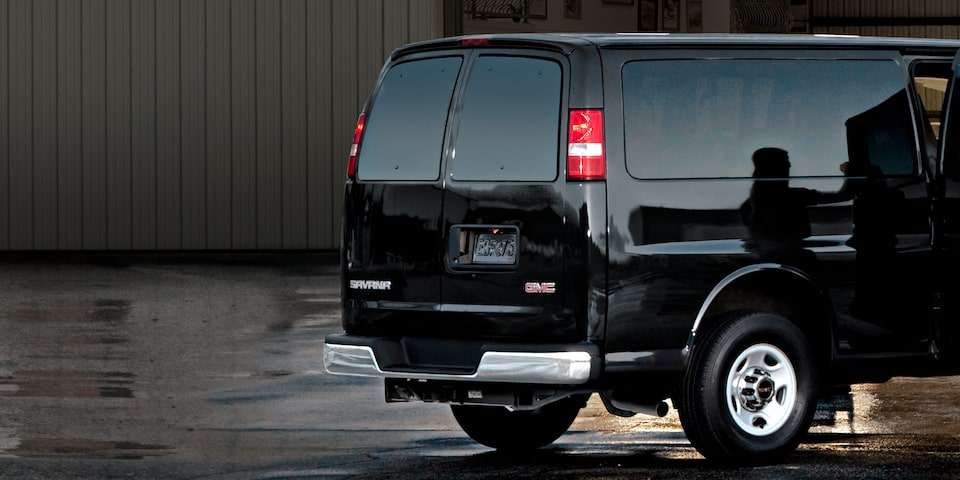 A Man With an Instrument Case Walking out of a GMC Savana Cutaway
