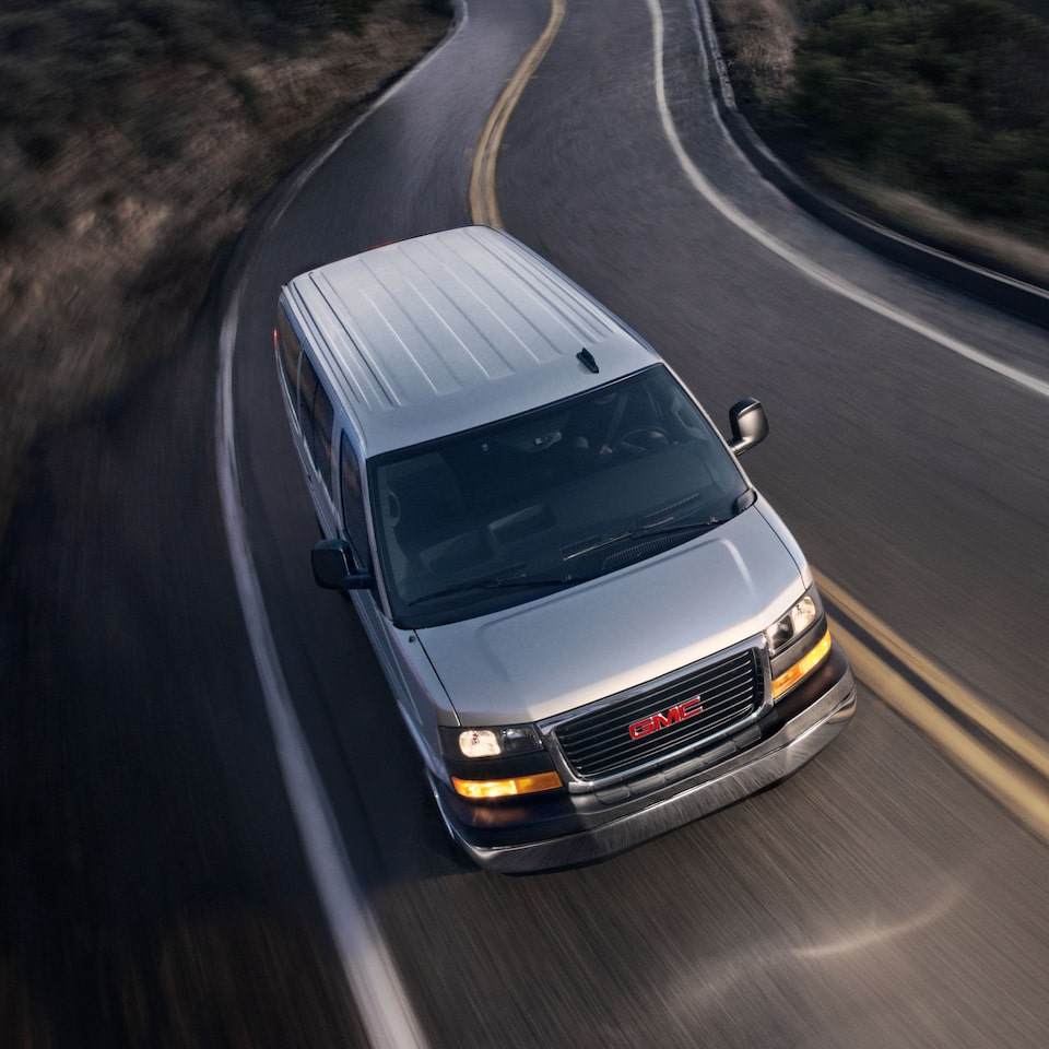 A Gray GMC Savana Passenger On The Road