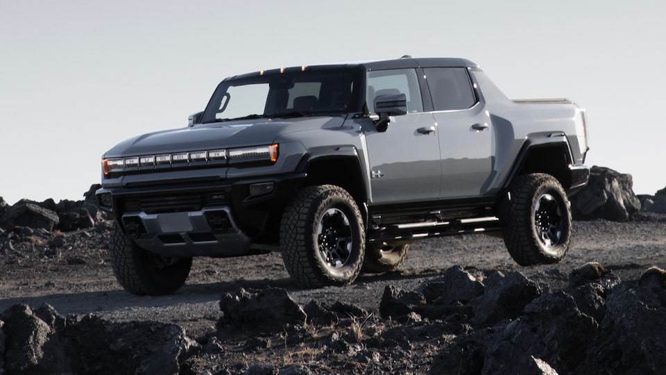 Front Three-Quarters View of a 2025 Hummer EV Pickup Truck Parked in the Rocky Mountains
