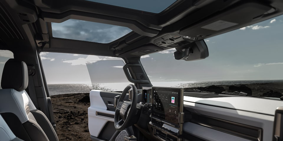 Side Interior Front View of a GMC Hummer EV SUV with the Front Door Opened on a Beach
