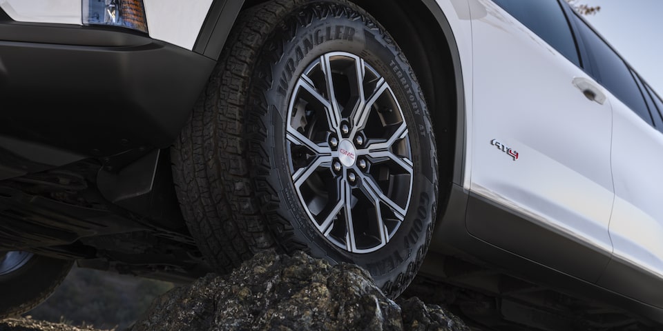 Close-up of the GMC Acadia AT4 Mid-Size Off-Road SUV Driving Over Rough Terrain