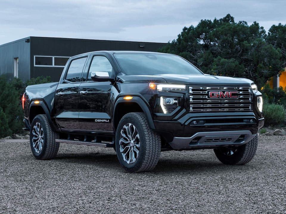 Three-quarter View of a 2025 GMC Canyon Denali Parked with the Headlights On