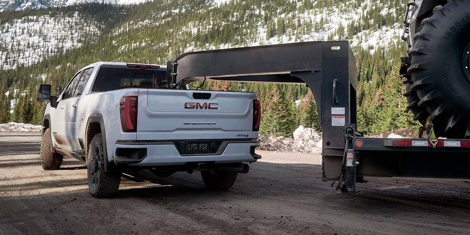 Rear View of a 2025 GMC Sierra HD AT4 Hauling a Large Trailer