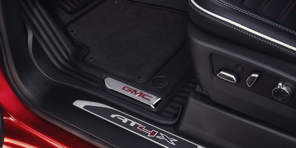 Close-up View of the Seat Controls and "AT4X" Branded Kickplate in a 2025 GMC Sierra HD AT4 Truck