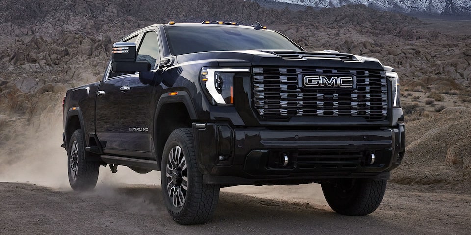 Front Three-Quarters View of a 2025 GMC Sierra HD Denali Truck Driving Through the Desert