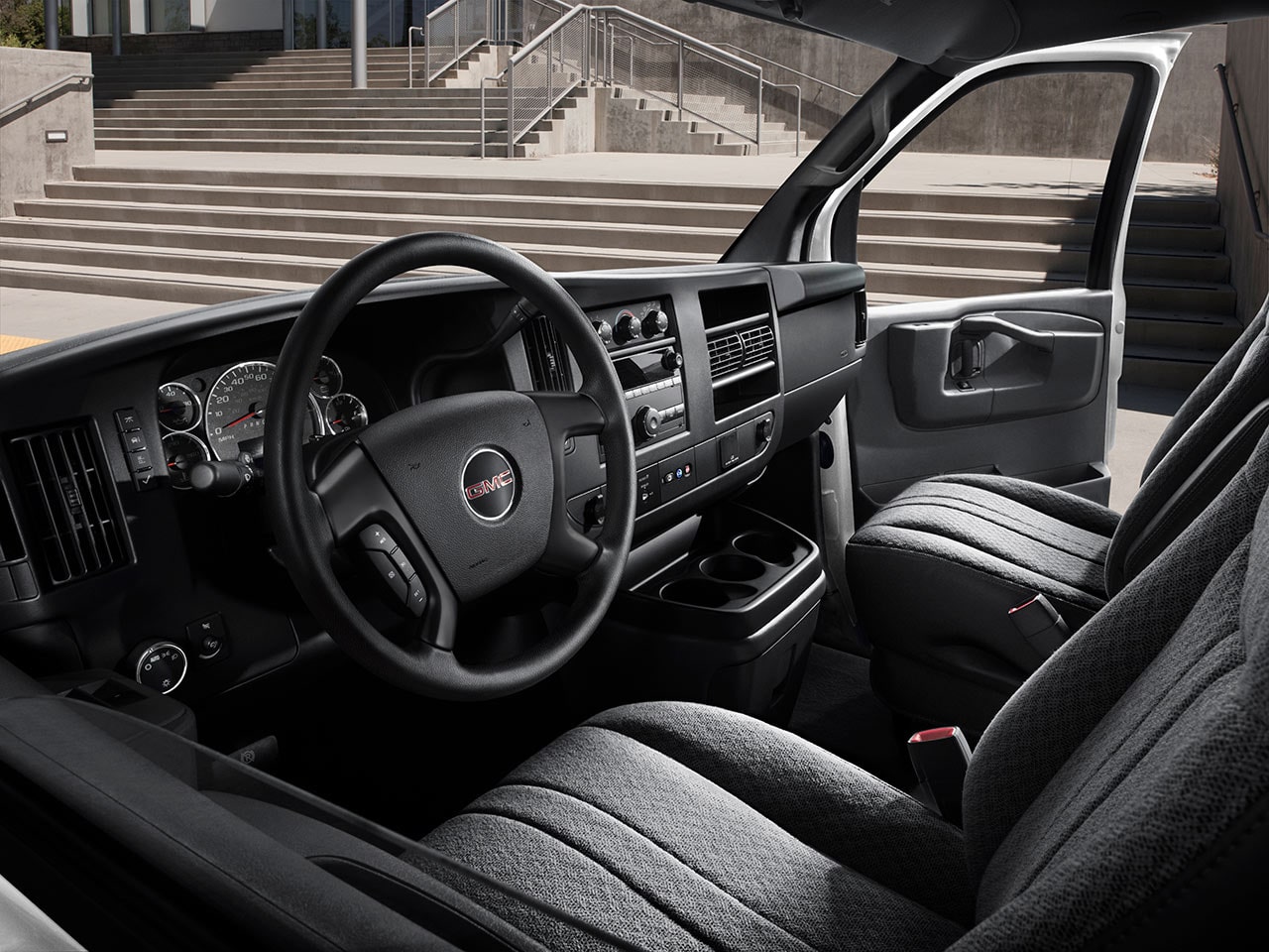 Interior View of the Steering Wheel, Dashboard, and Seating in a 2026 GMC Savana Passenger Van