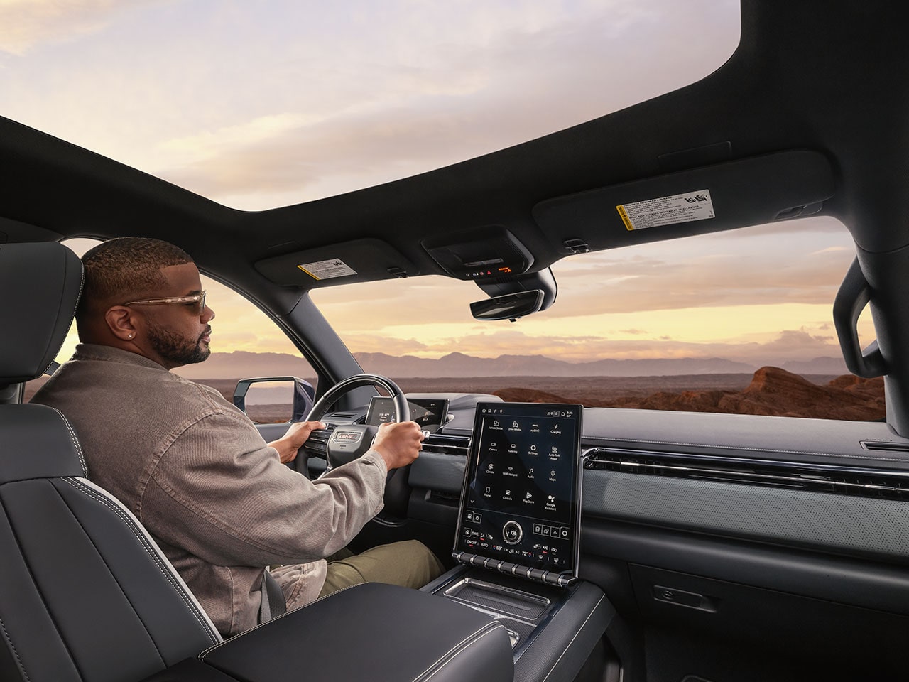 Over the Shoulder View of a Man Driving the 2026 GMC Sierra EV AT4