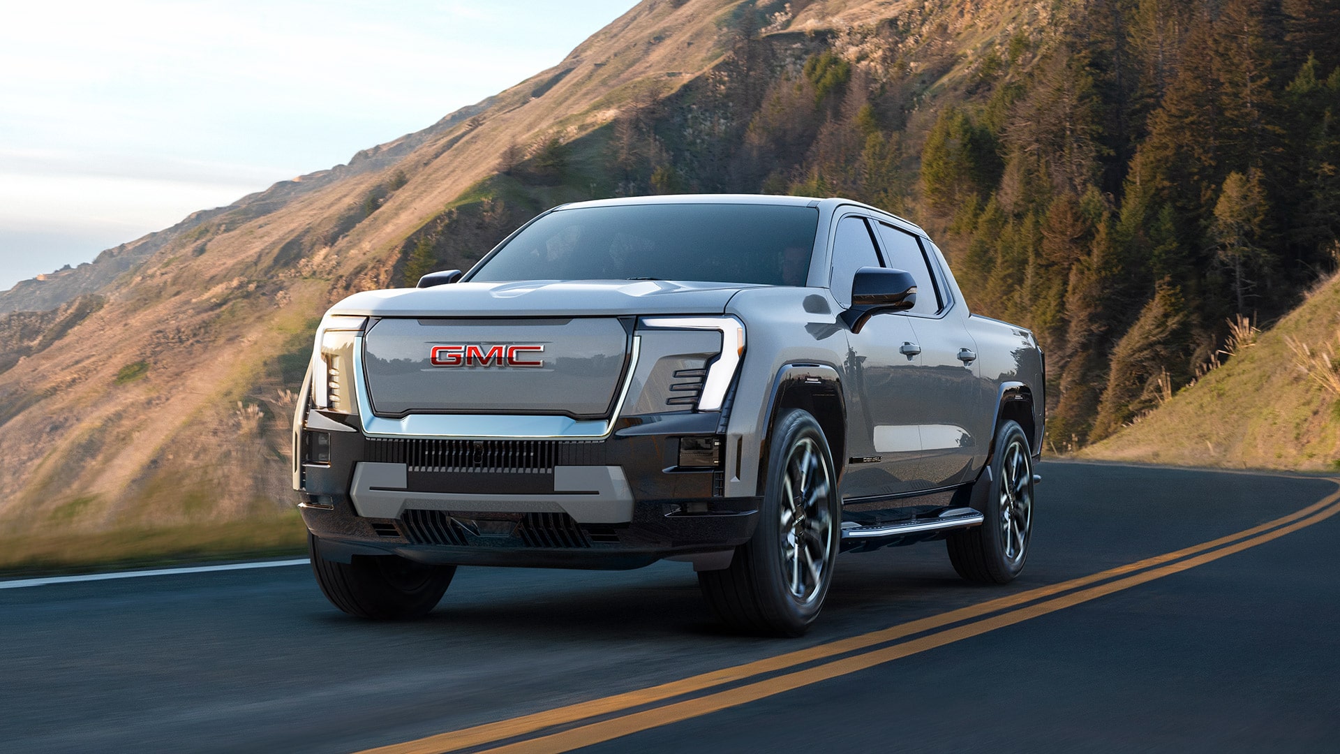 The 2026 GMC Sierra EV Denali Driving Down a Mountain Road