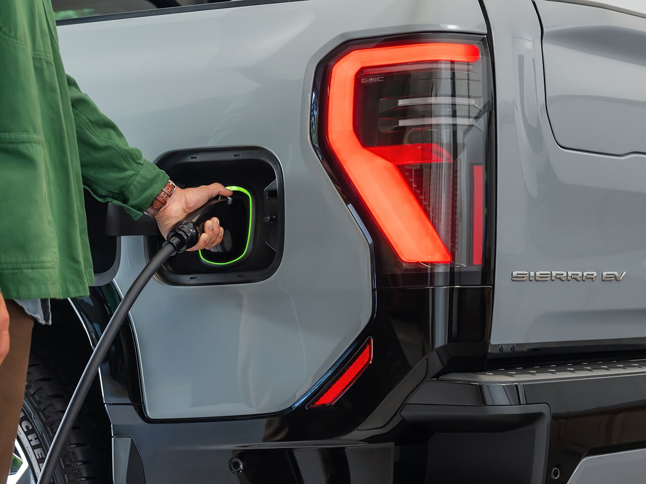 A Man Charging his 2026 GMC Sierra EV Elevation Pickup Truck