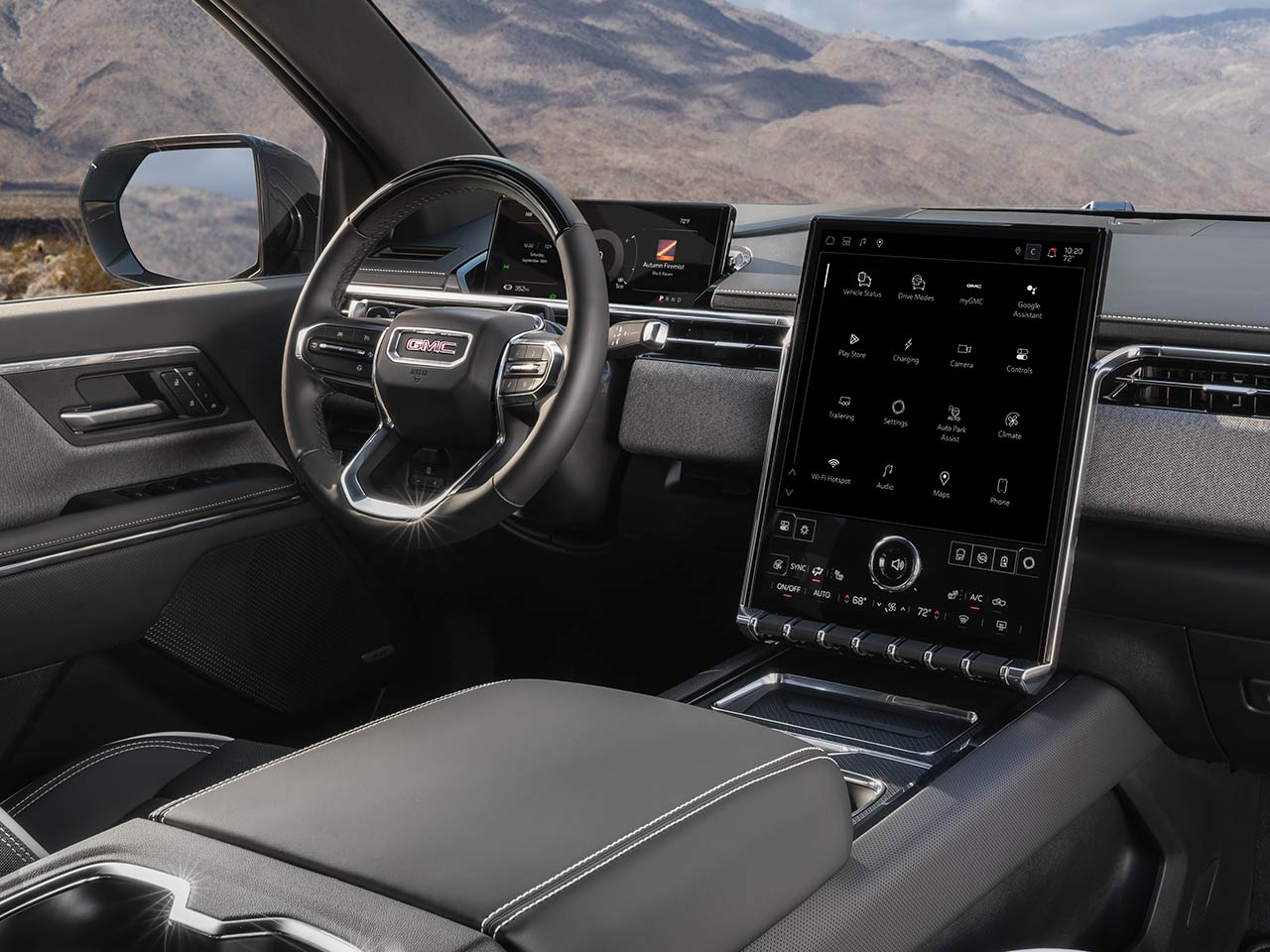 Front View of the 2026 GMC Sierra EV Elevation Driving Down the Open Road with a Mountain Range in the Distance