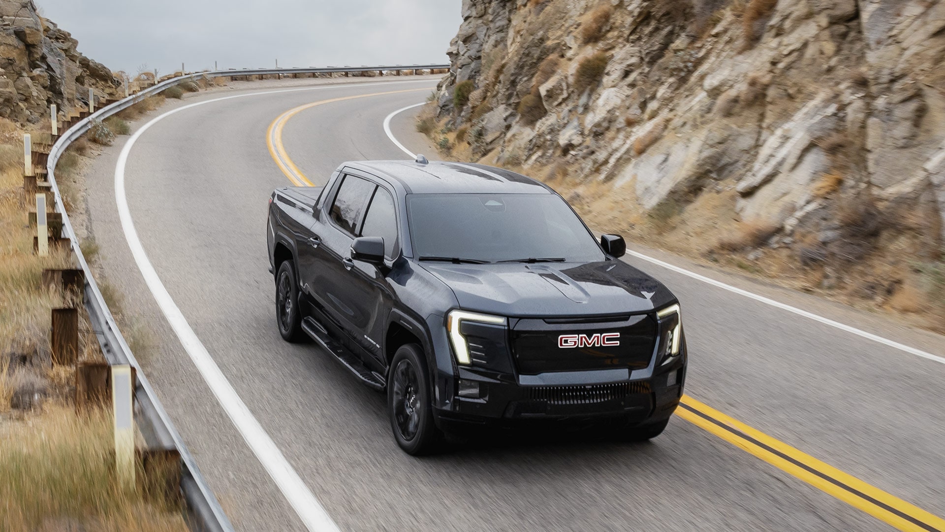 Birds-eye View of the 2026 GMC Sierra EV Elevation Diving Down a Winding Road