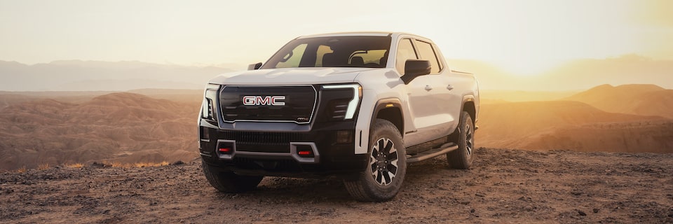 Three-quarters View of a 2026 GMC Sierra EV Pickup Truck Parked in the Desert Gleaming Under the Sun