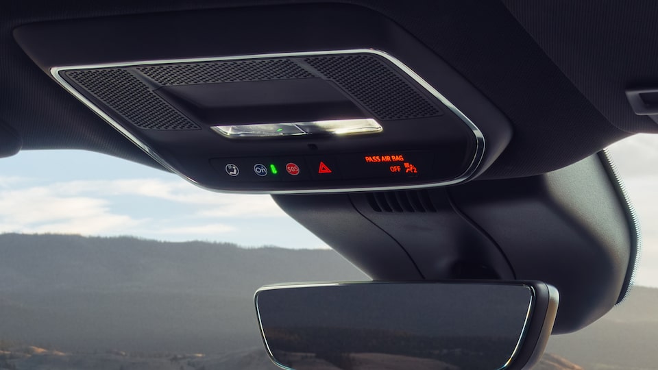 Close-up of Someone About to Press the OnStar Button near the Rear View Window