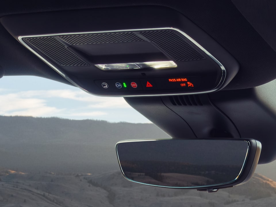 Close-up of Someone About to Press the OnStar Button near the Rear View Window