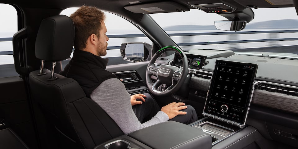 A Man Driving the 2026 GMC Sierra EV Hands-free Utilizing the Super Cruise Driver Assistance Technology