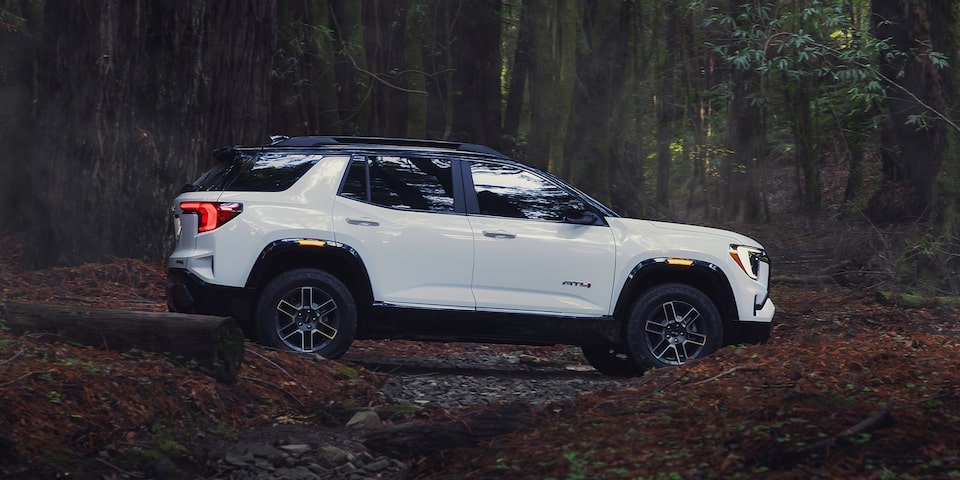 Profile View of the 2026 GMC Terrain AT4 Small Off-Road SUV Driving Through the Forest
