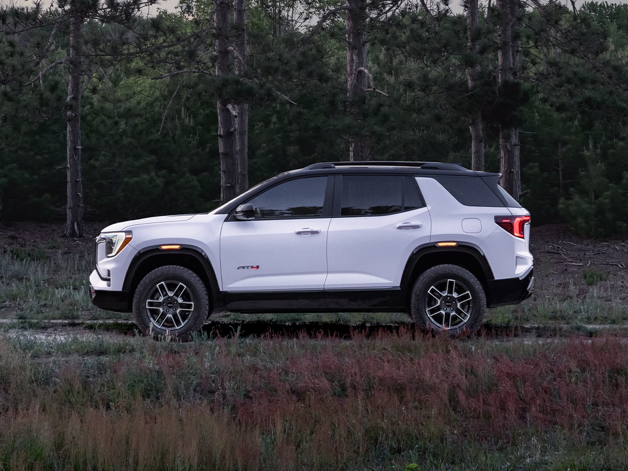 Profile View of the 2026 GMC Terrain AT4 Small Off-Road SUV Driving Through the Forest