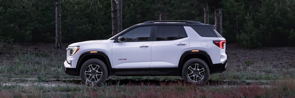 Profile View of the 2026 GMC Terrain AT4 Small Off-Road SUV Driving Through the Forest