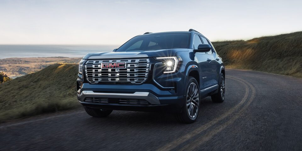 Front Three-Quarters View of a 2026 GMC Terrain Denali Luxury SUV Driving Down the Coast