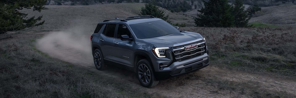 The 2026 GMC Terrain Elevation Compact SUV Driving up a Dirt Road at Dusk