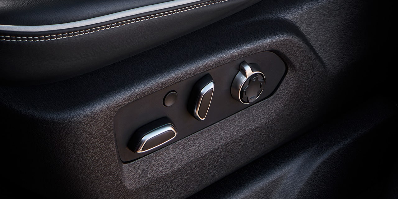 Close-up View of the Seat Controls and "AT4X" Branded Kickplate in a 2026 GMC Sierra HD AT4 Truck