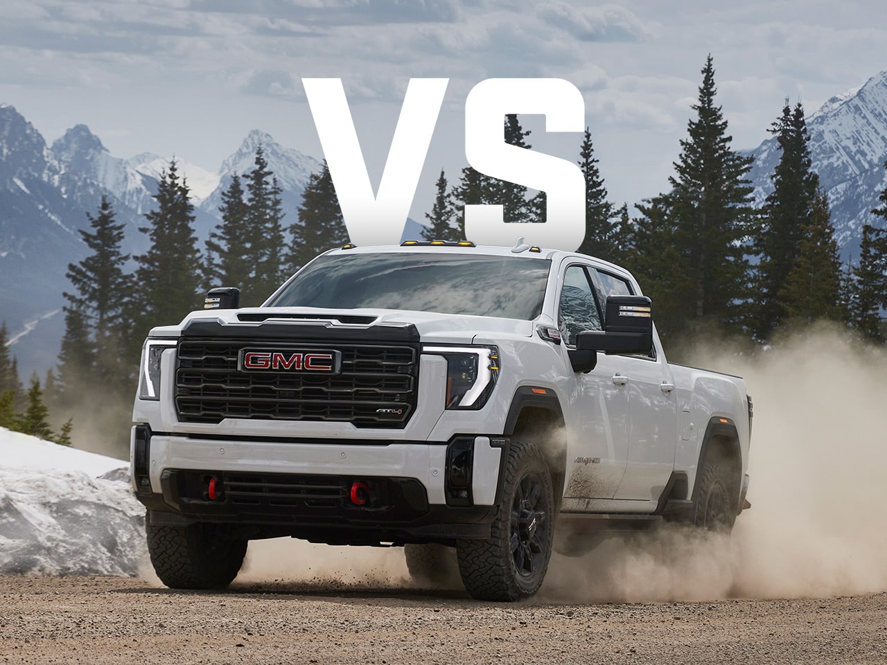 A Low Front View of the 2026 GMC Sierra EV Driving Through a Mountain Road