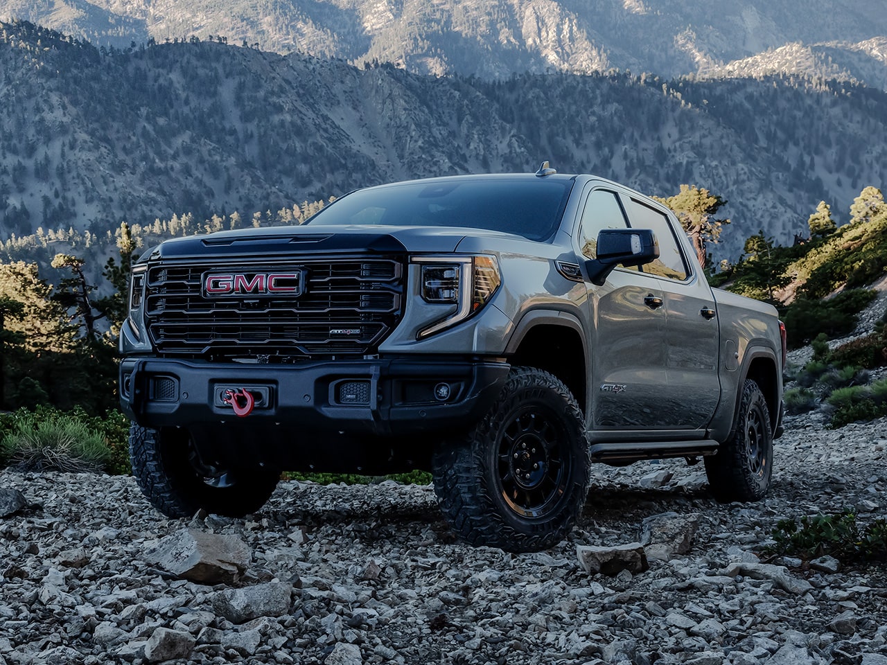 The 2026 GMC Sierra AT4 Off-Road Truck Parked on Rocky Terrain with Mountains in the Distance