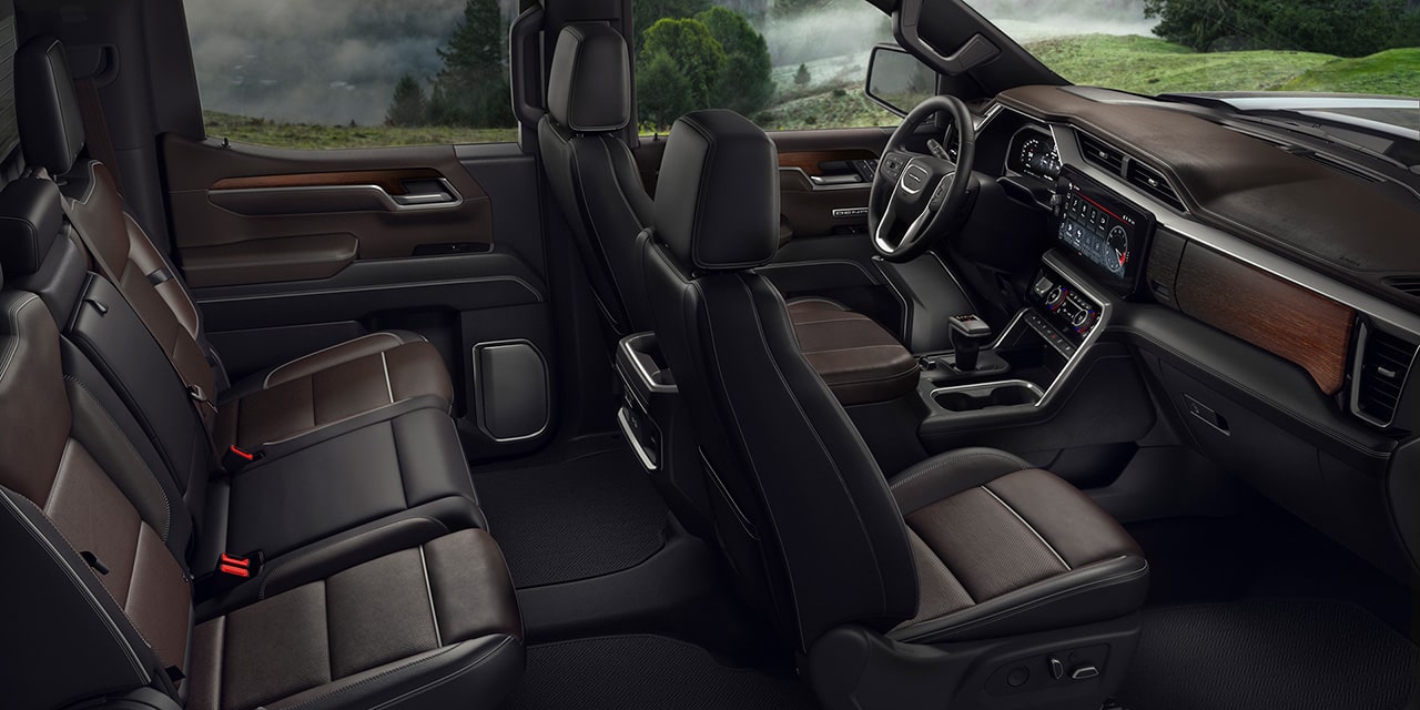 The Interior of a GMC Sierra Crew Cab with Brown and Black Leather Seats and Wood Trim