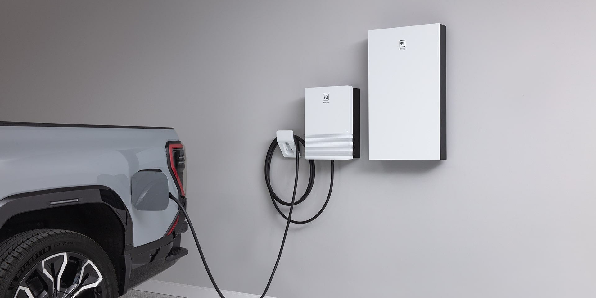 A GMC Sierra EV Plugged into a Wall-mounted Charging Station