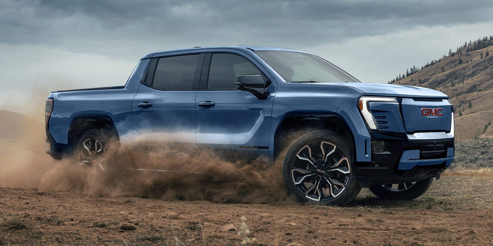 A Bold Blue GMC Sierra EV Denali Powering Through Dirt in a Rugged Off-road Environment