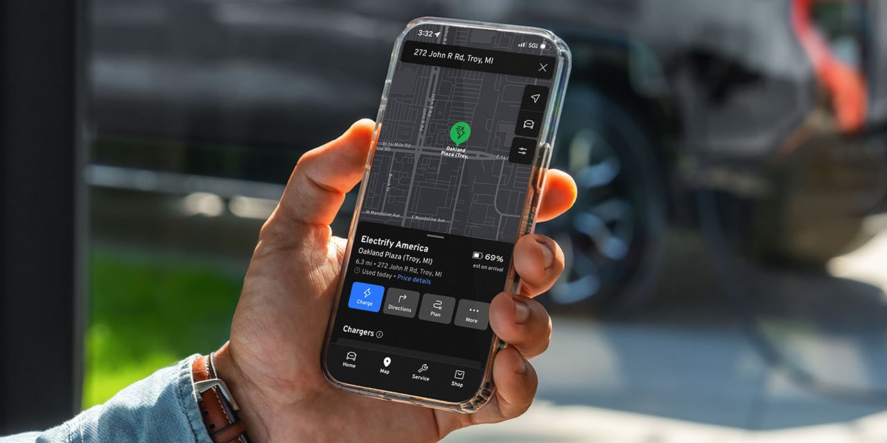 A User Holding a Smartphone Displaying the myGMC Mobile App for the Sierra EV