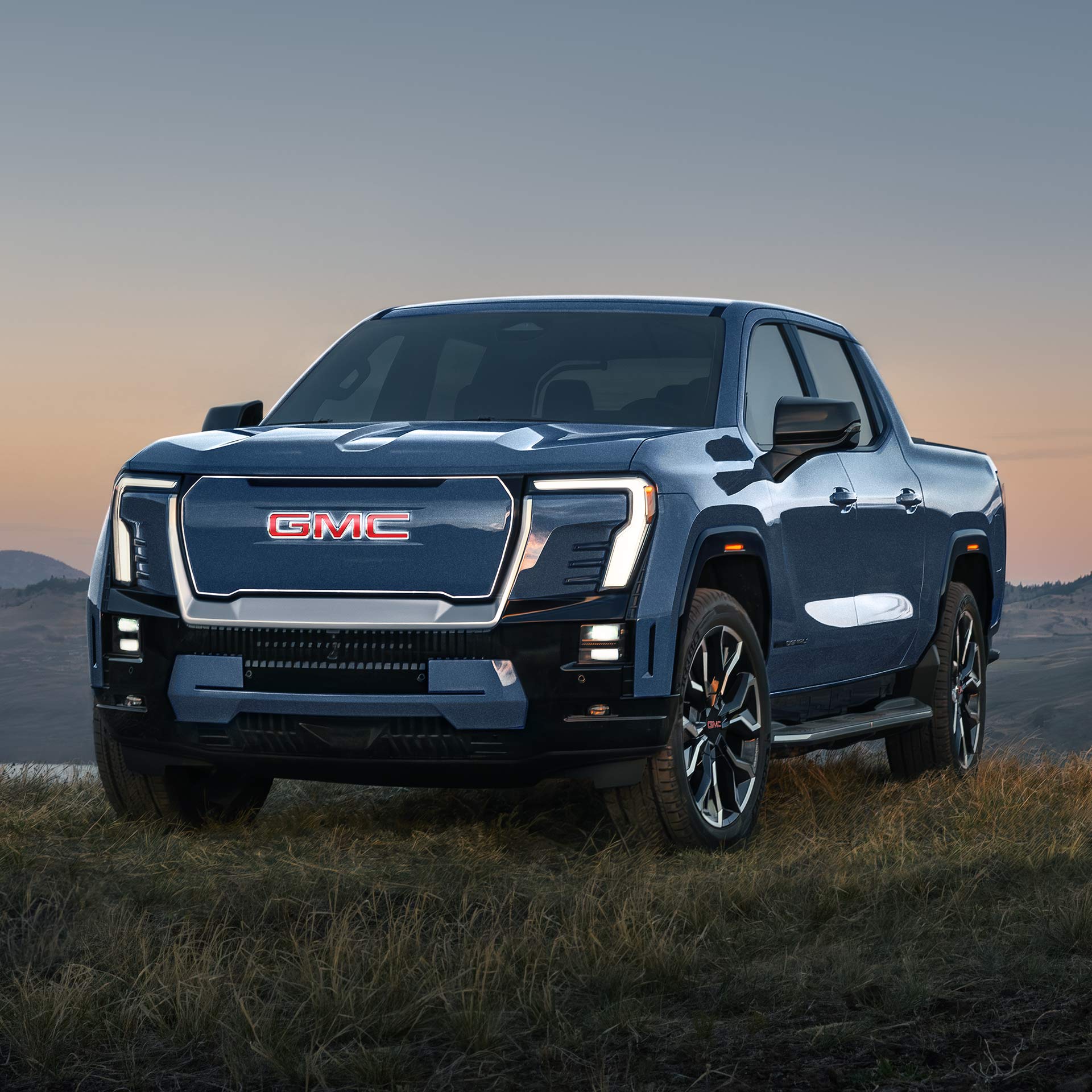 A Close Front View of a GMC Sierra EV Denali with an Illuminated Badge